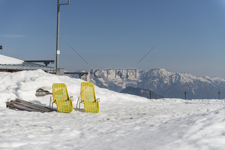 两个黄色的阳光躺椅躺在积雪覆盖