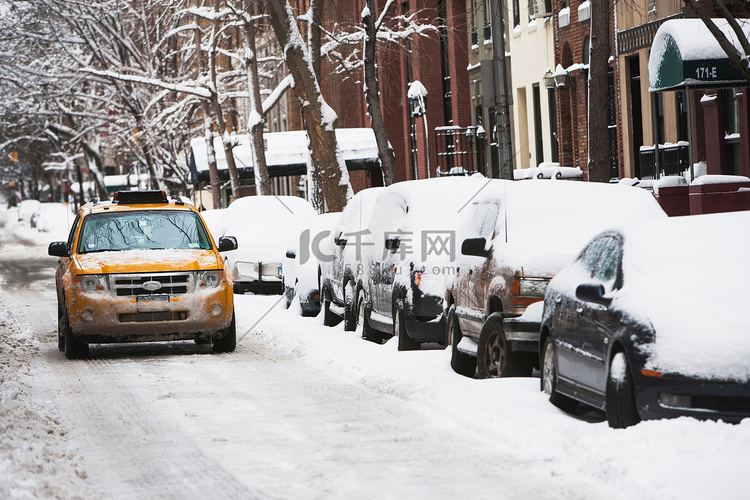 在积雪的城市街道上驾驶出租车