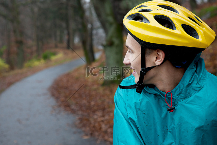 一名戴着自行车头盔的年轻人在森