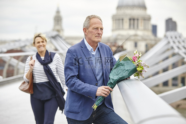 英国伦敦千禧桥上成熟男子手持花
