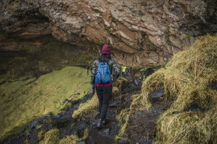 两名游客走在冰岛瀑布的小路上