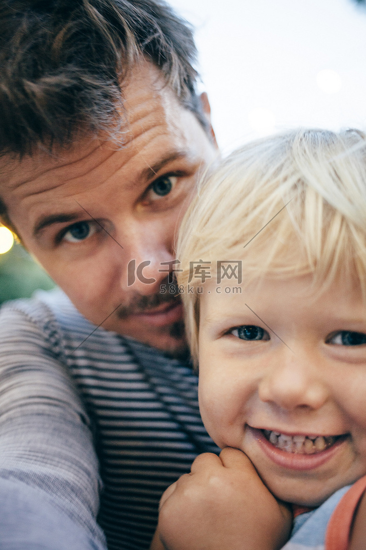 父亲和金发女郎微笑着看着相机的