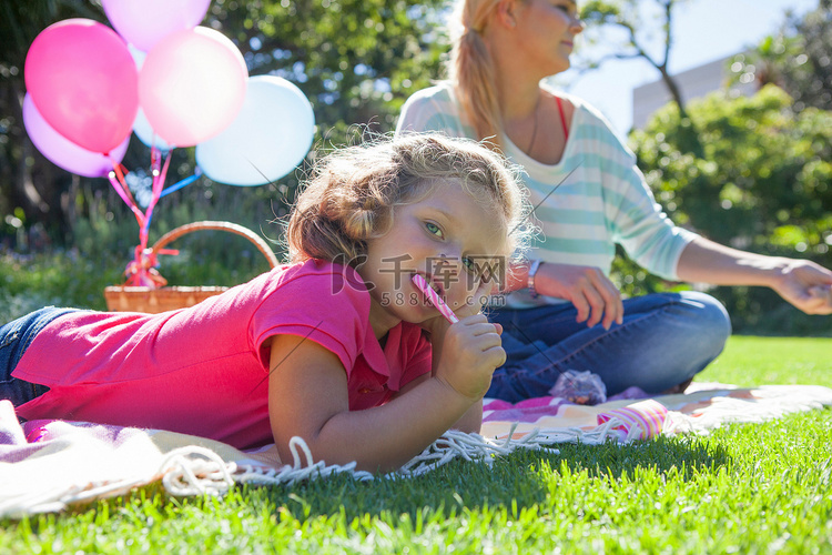 在花园里用毯子吃拐杖糖的女孩