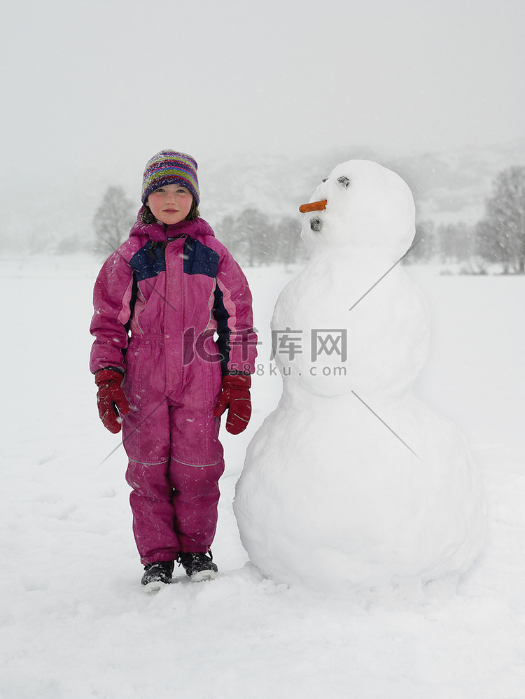 站在雪人旁边的女孩