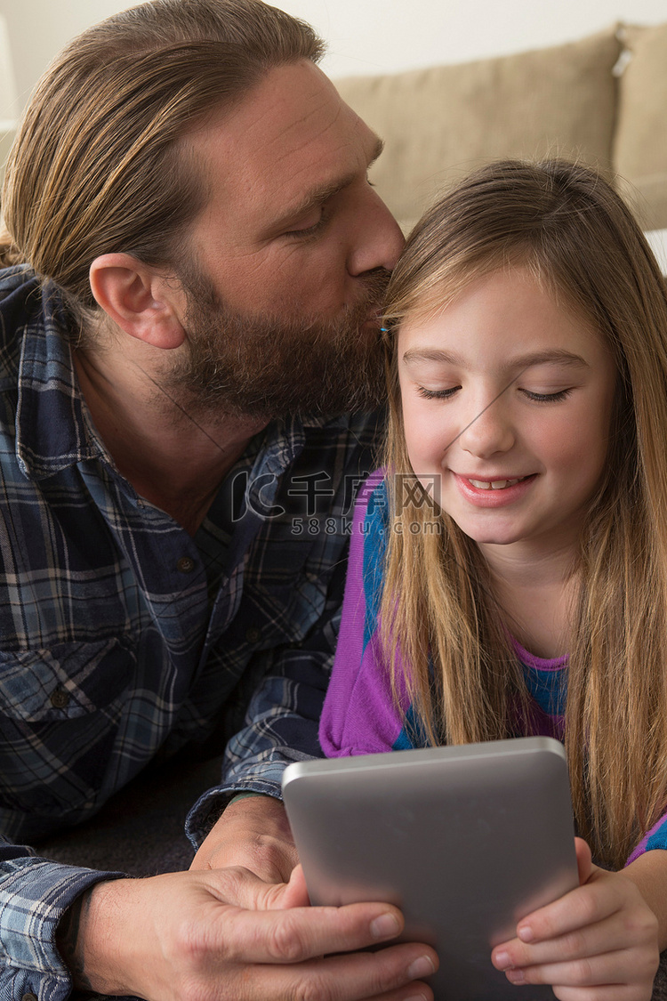 女孩和父亲一起看数字平板电脑