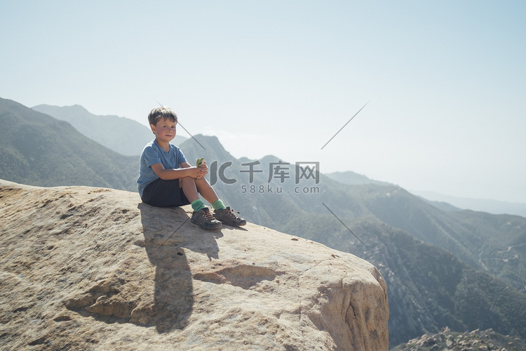 坐在巨石上的男孩肖像美国加利福