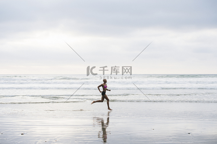 一名比基尼女子在海滩上慢跑