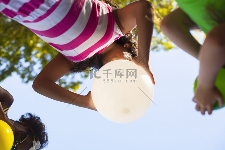 三个女孩在花园里吹气球的低角视