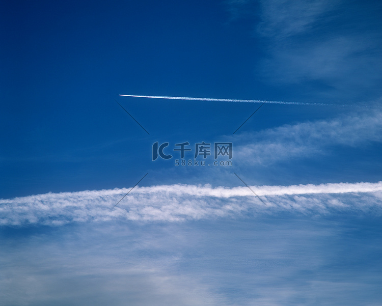 飞机在天空中划过一条雾气的轨迹