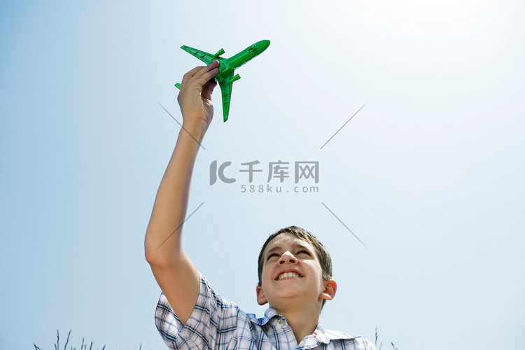 男孩高高举起玩具飞机