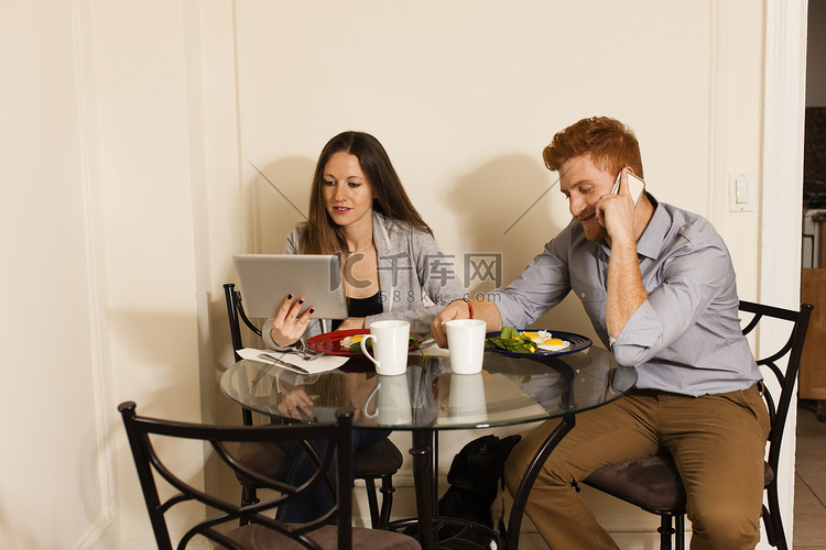 情侣在餐桌上使用智能手机和数字