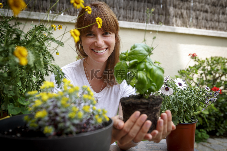 中年妇女手捧罗勒植物对着镜头微