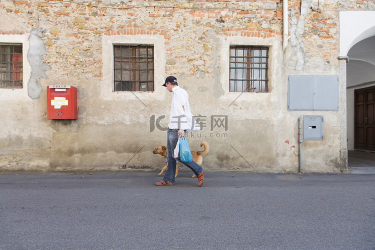 男人遛狗在街上苏诺诺瓦拉意大利
