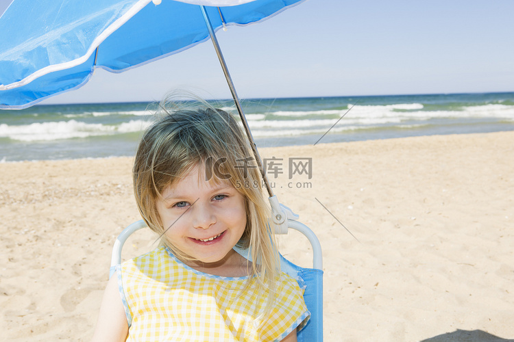 海滩上披着遮阳伞的女孩肖像