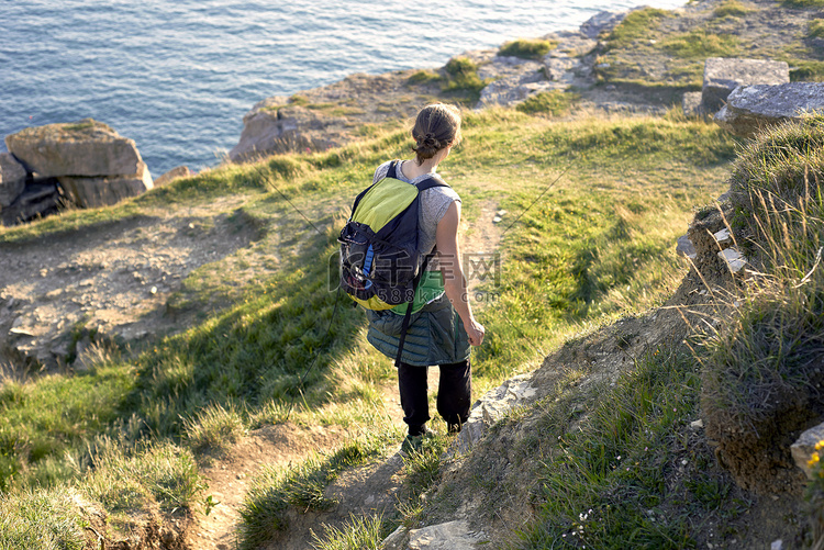 徒步旅行者背着背包沿着悬崖边徒