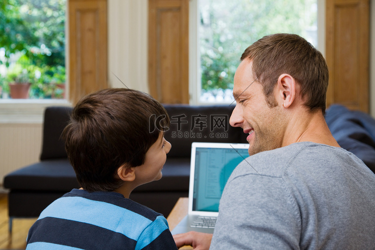 父子俩使用笔记本电脑