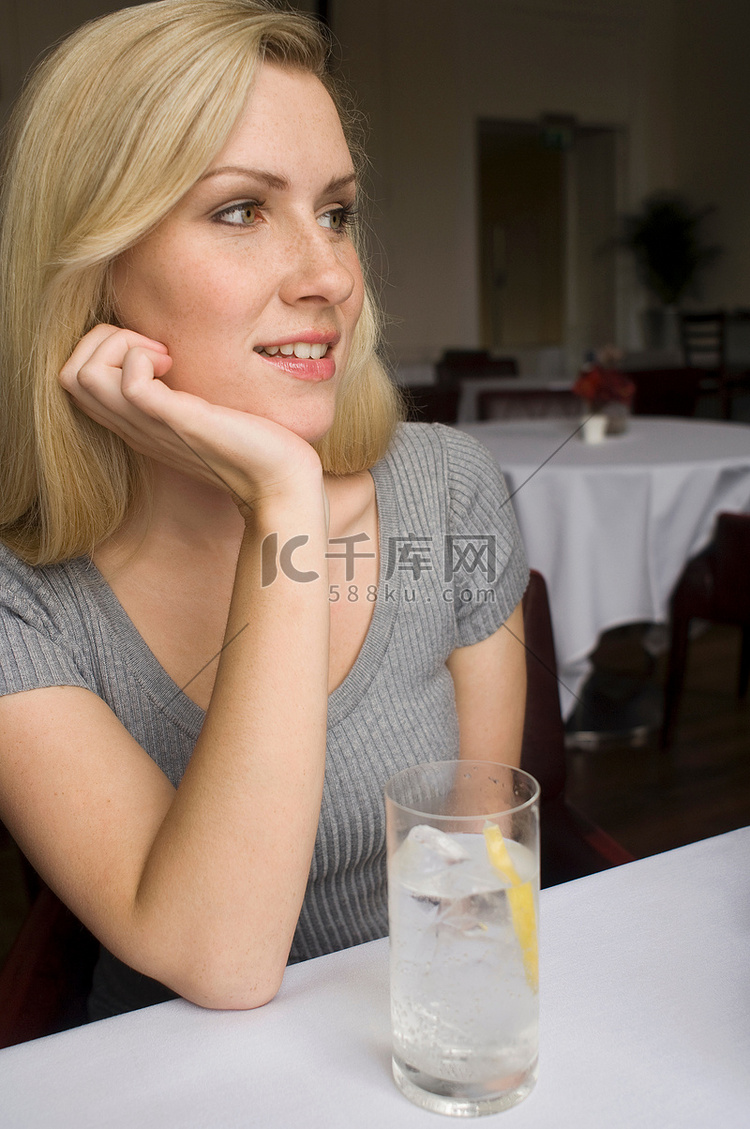 一位女士在咖啡馆喝着一杯水