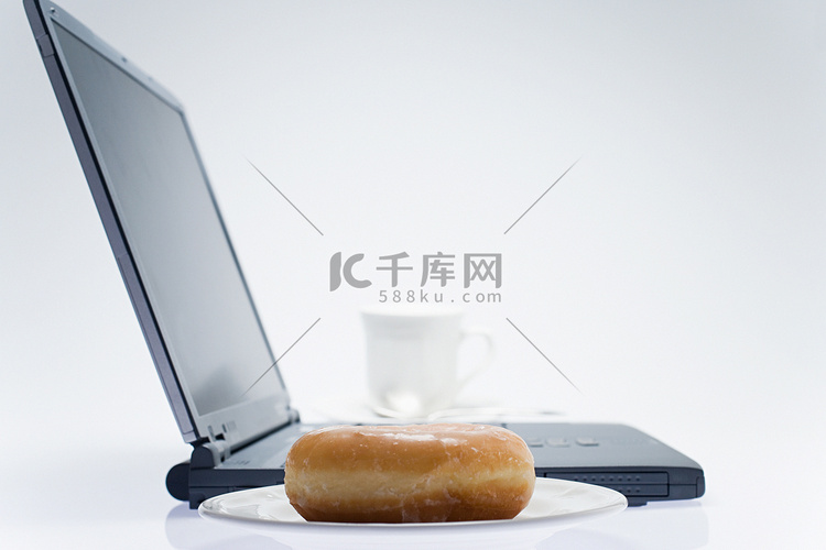 笔记本电脑旁的咖啡和甜甜圈