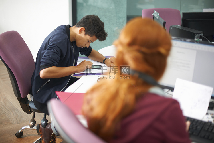 年轻的男女大学生在电脑桌前