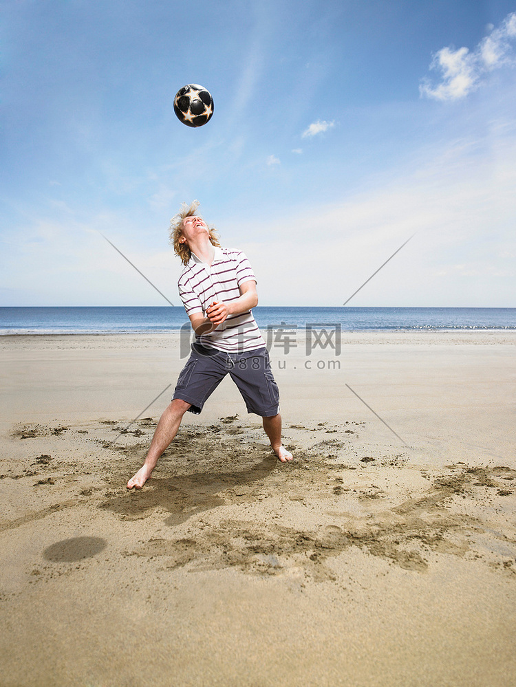 海滩上踢足球的年轻人