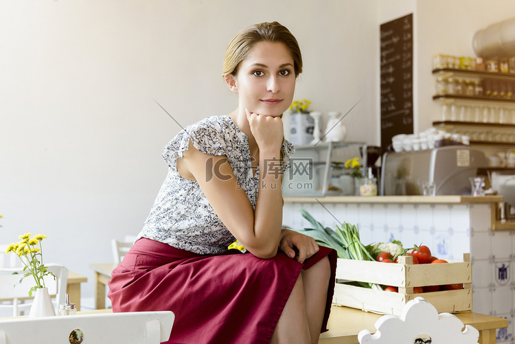 坐在咖啡桌上的年轻女子看着相机
