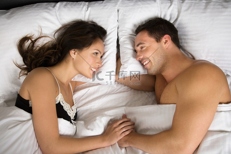 一对夫妇面对面地躺在床上