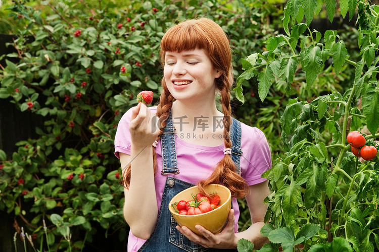 女人看着自家种的草莓