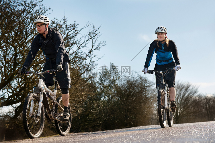 一对夫妇在乡村公路上骑自行车