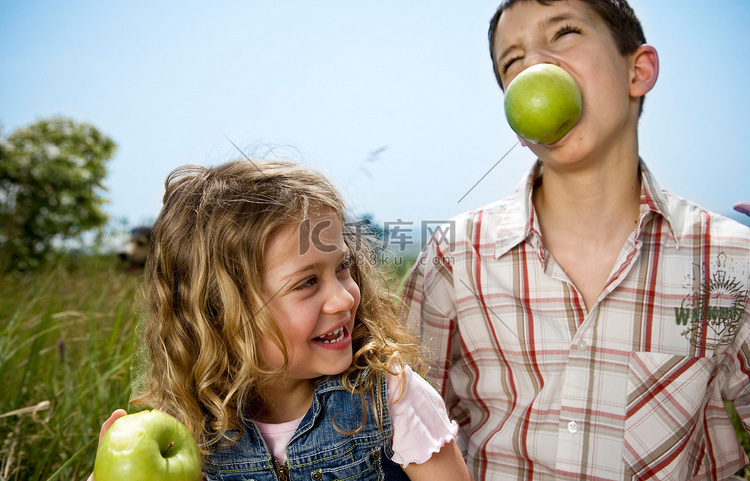 男孩和女孩含着苹果