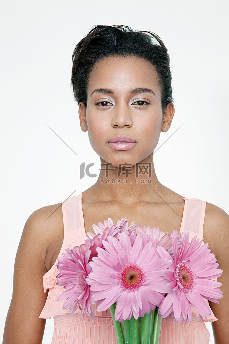 一位手持粉色花朵的年轻女子