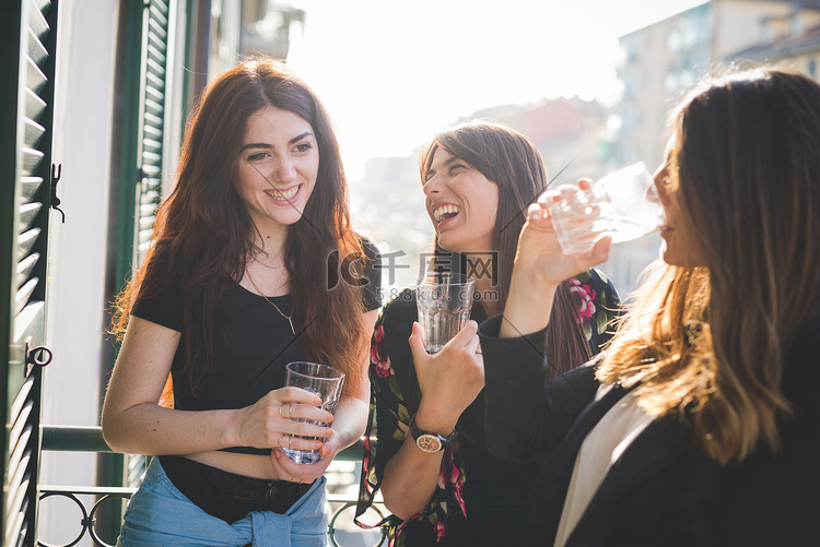 三个年轻的女性朋友在海滨阳台上