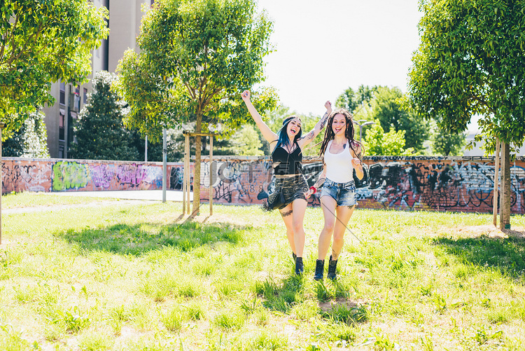 两名年轻女子在城市公园嬉笑奔跑