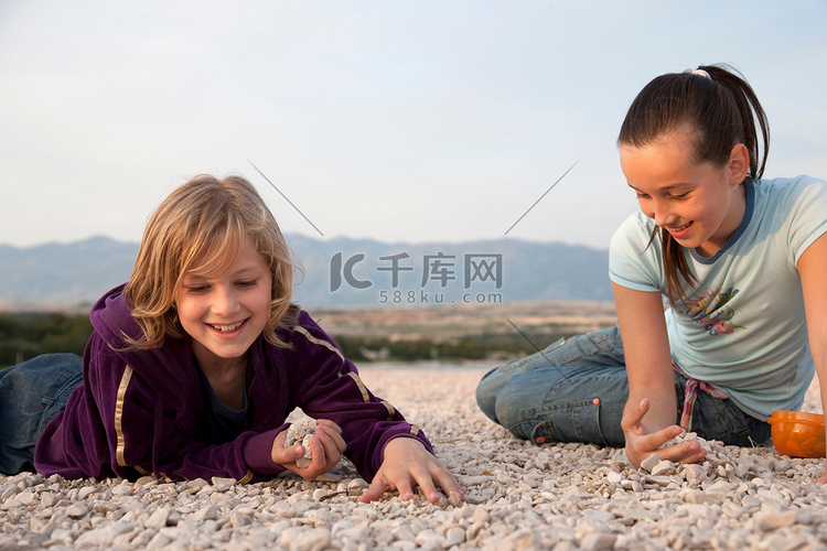 女孩们在海滩上捡石头