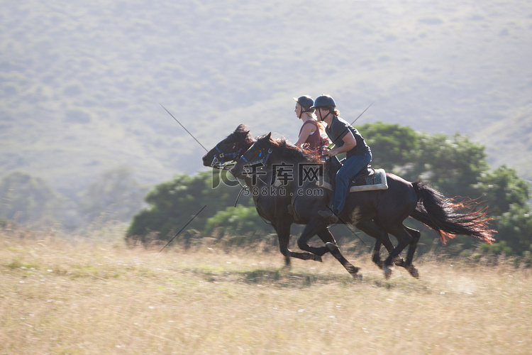 一对夫妇在乡村景观中骑马