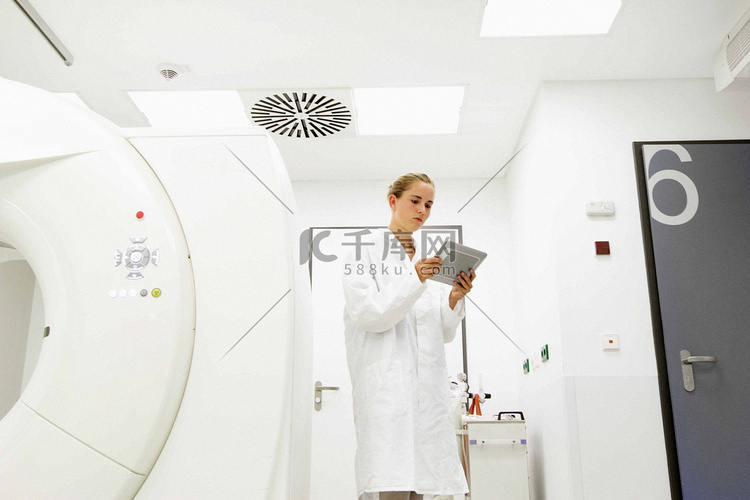 女医生在治疗室看着数字平板电脑