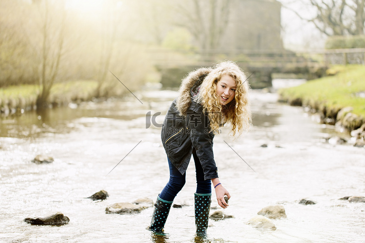 十几岁的女孩在乡下的河里捡石头