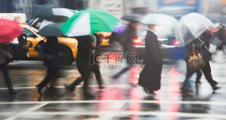 排队的人在雨中穿过城市街道