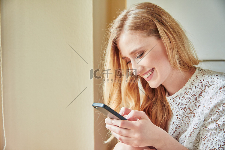 一名年轻女子在家阅读智能手机短