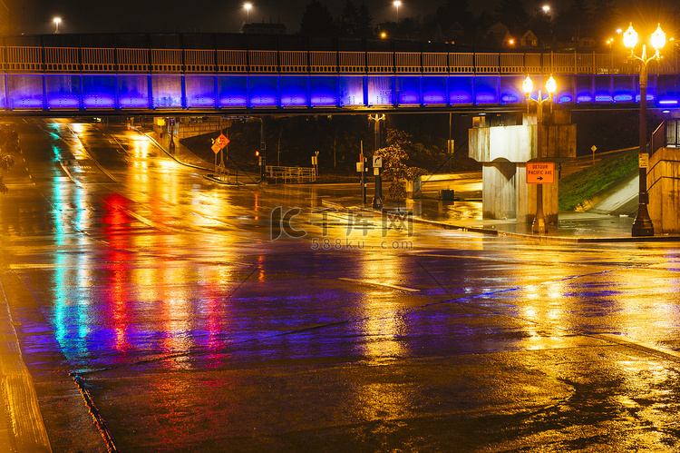 夜间潮湿的城市道路上的人行桥美