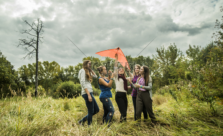 五名年轻女子在灌木丛中放着风筝