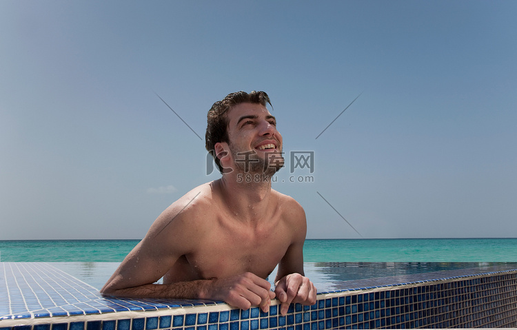 男人在无边泳池中放松