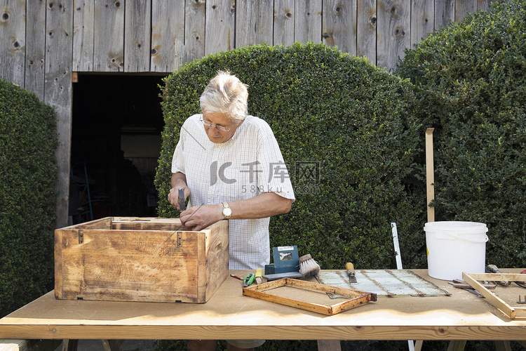 花园里制作木板箱的老人