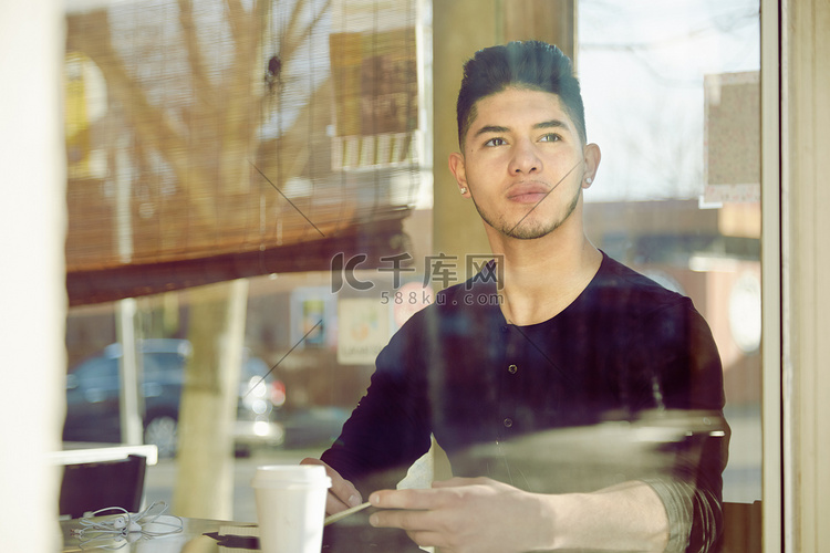 咖啡馆里的年轻人看着窗外