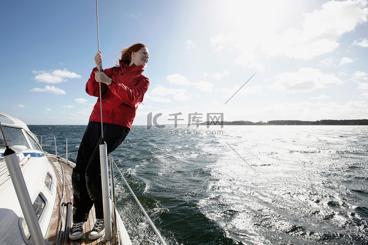 一名年轻女子在游艇上抓着绳子