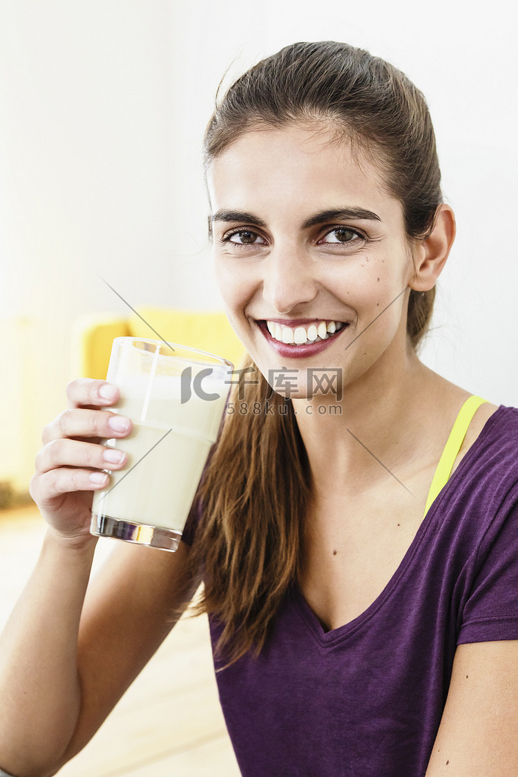 年轻女子喝着果汁休息锻炼的肖像