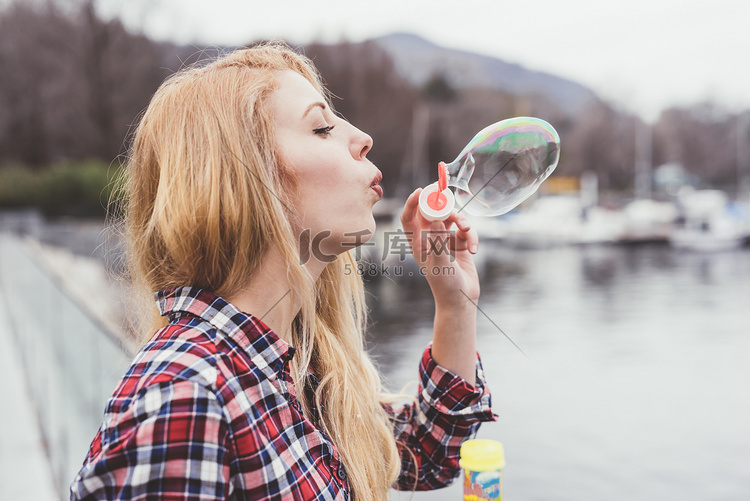 年轻女子在海边吹泡泡科莫湖意大