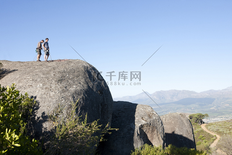 年轻的男性登山者在岩石上系上绳