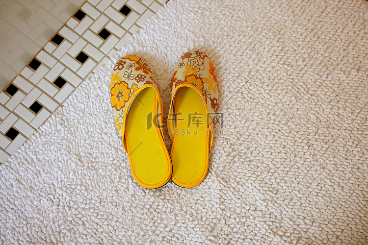 地毯上的一双黄色拖鞋