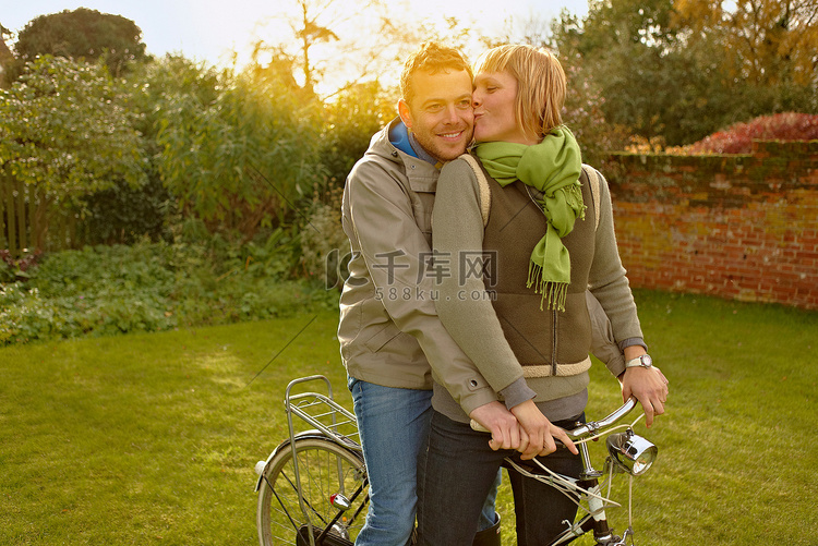 一对骑着旧自行车的情侣接吻秋天
