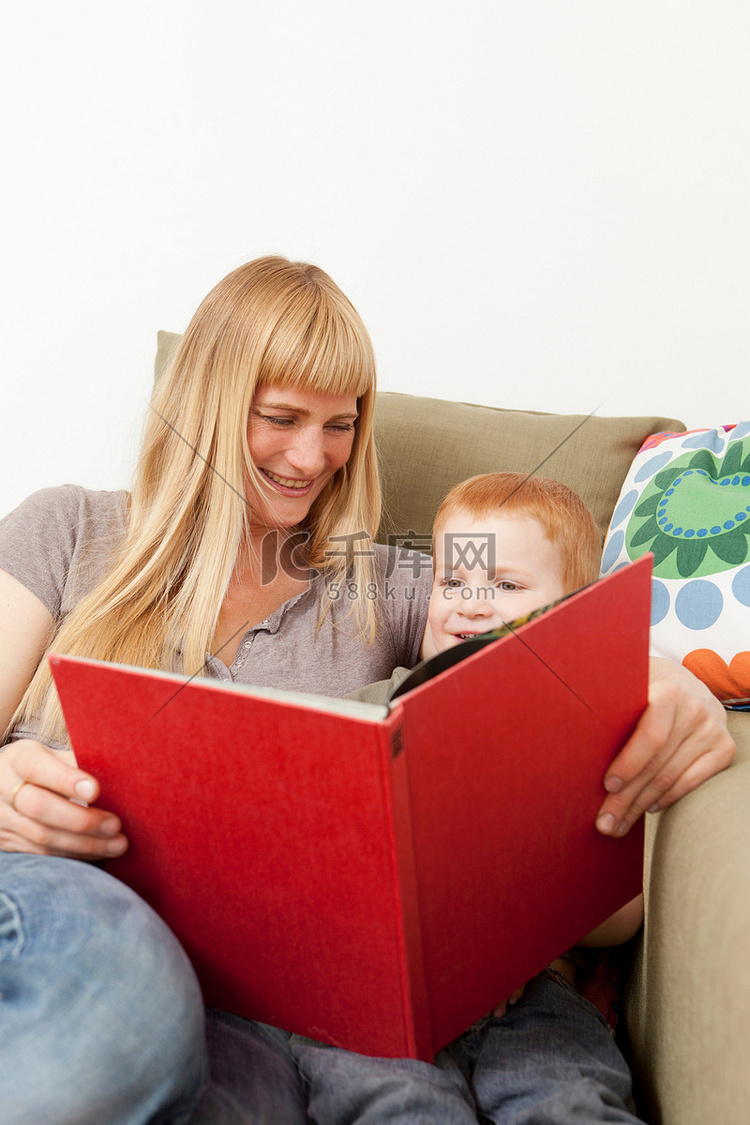 母子俩坐在沙发上一起看书